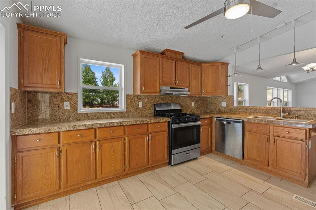 Image 6 of 24: Kitchen with stainless steel appliances, under cabinet range hood, healthy 