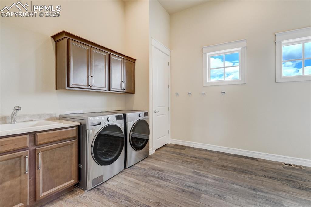 Image 23 of 50: Laundry room with utility sink & leads to the garage.