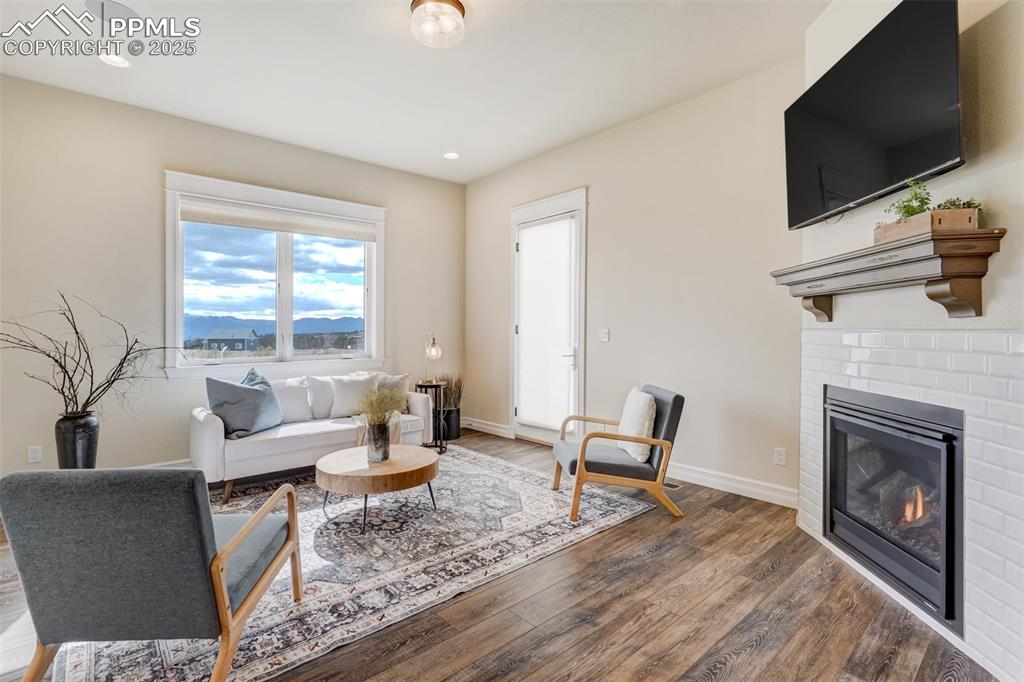 Image 40 of 50: Living room with gas fireplace. Door leads to private patio area.