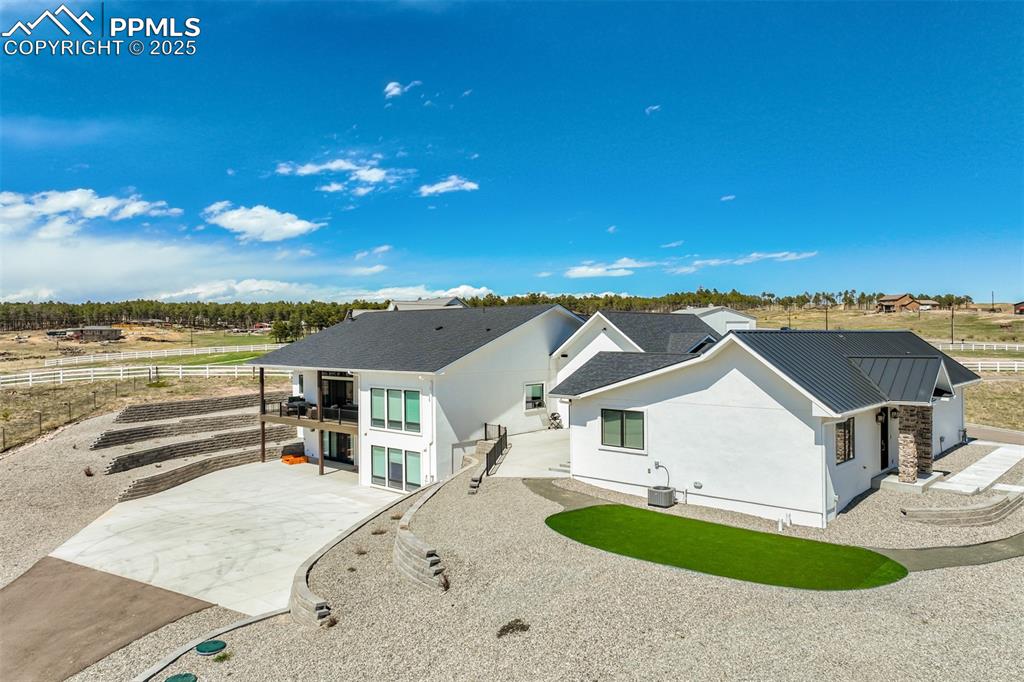 Image 48 of 50: Rear of home with driveway to the back of the home as well.
