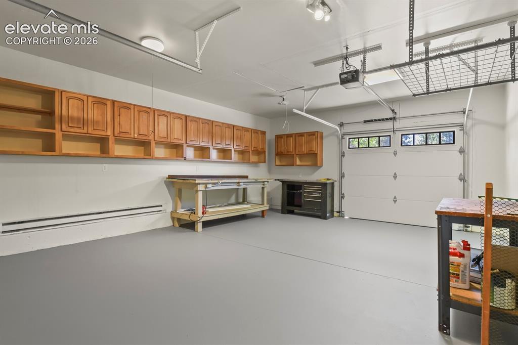 Image 29 of 50: 3 rd car oversized garage with high efficiency doors & work shop area