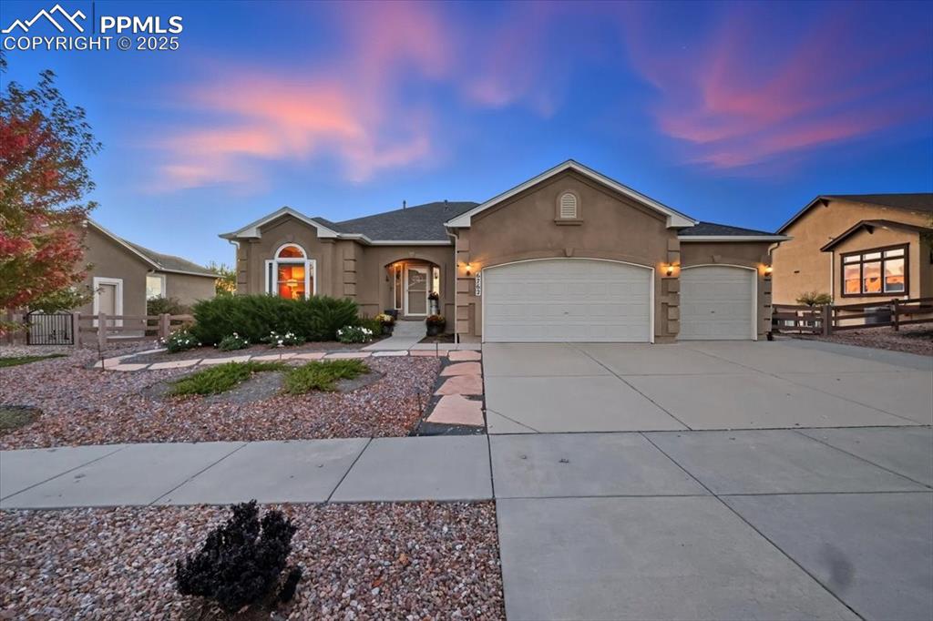 Caption: Ranch-style house featuring a 3 car garage, stucco siding, and concrete driveway