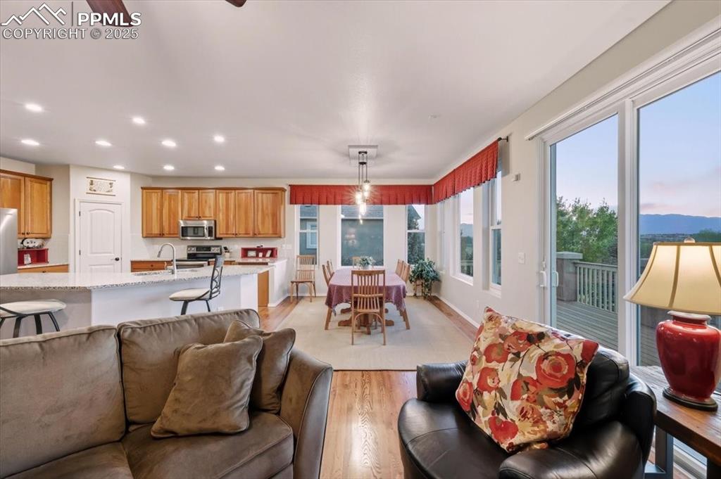 Image 11 of 26: Living area featuring light wood-style flooring, recessed lighting, and a c