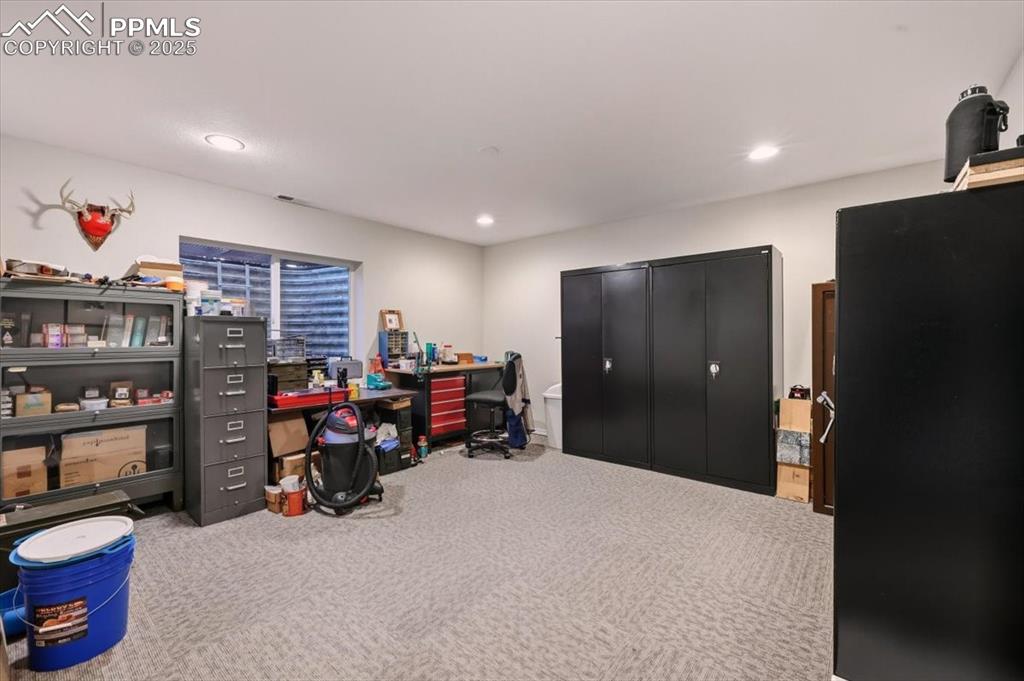 Image 20 of 26: Bedroom used as an office, with carpet floors and recessed lighting