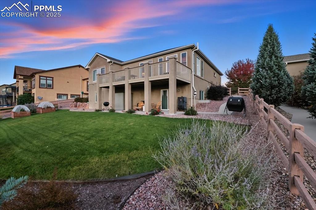 Image 22 of 26: Back of house at dusk with a patio area, stucco siding, and a deck
