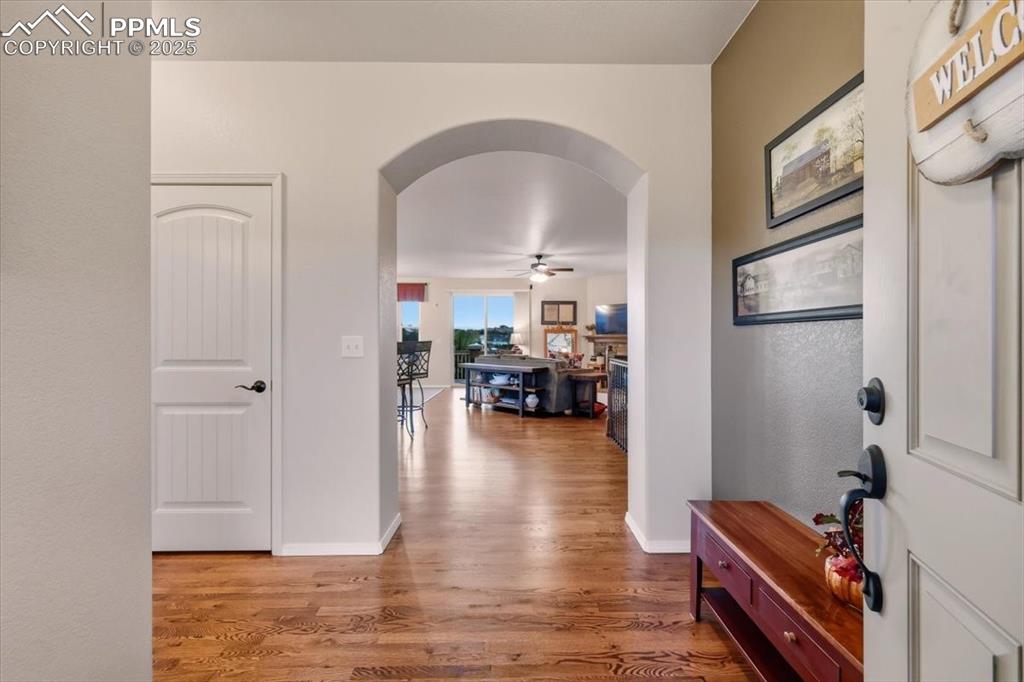 Image 4 of 26: Entry corridor with arched walkways and light wood-type flooring