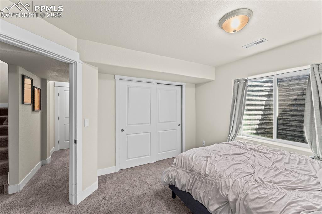 Image 15 of 33: Bedroom featuring carpet floors, a closet, and a textured ceiling