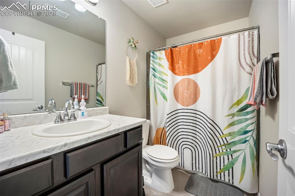Image 16 of 45: Bathroom with vanity, curtained shower, and tile patterned flooring
