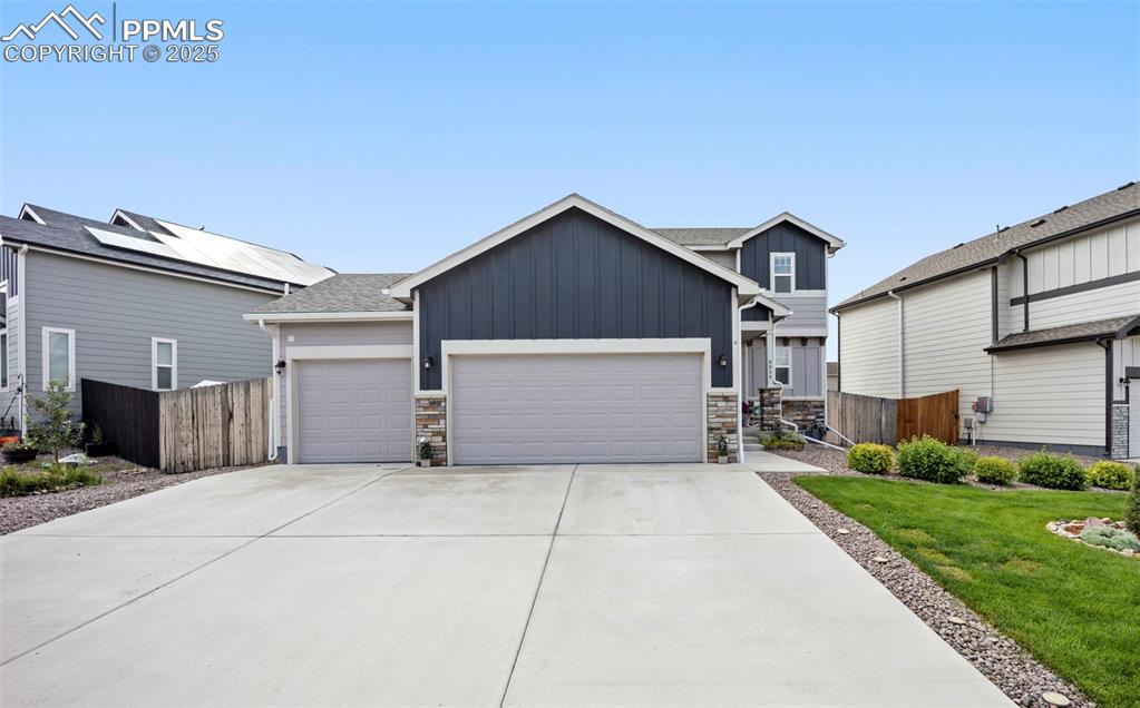 Image 2 of 45: Craftsman house with board and batten siding, stone siding, concrete drivew