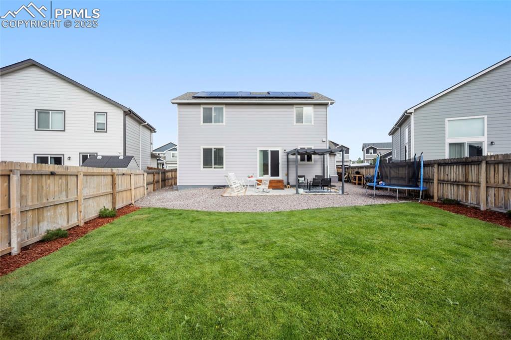 Image 29 of 45: Rear view of property featuring roof mounted solar panels, a patio area, a