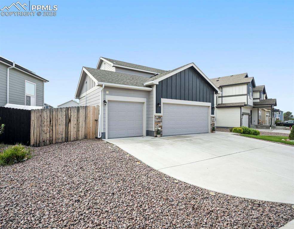 Image 3 of 45: View of front of house featuring board and batten siding, concrete driveway