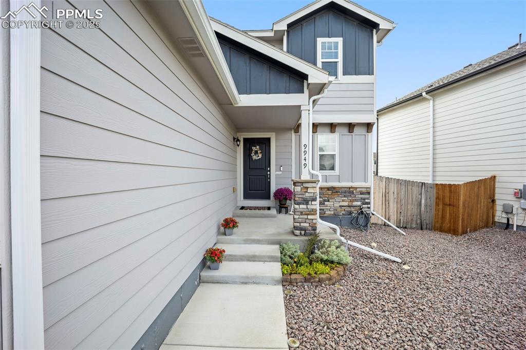 Image 4 of 45: Property entrance with board and batten siding and stone siding