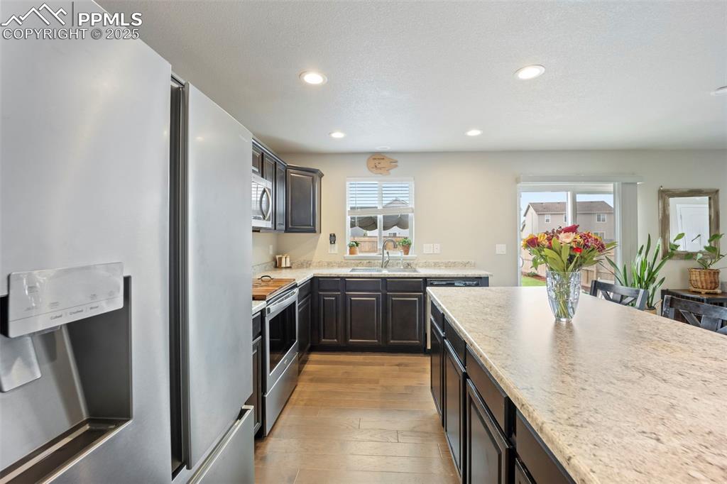 Image 8 of 45: Kitchen with appliances with stainless steel finishes, recessed lighting, l