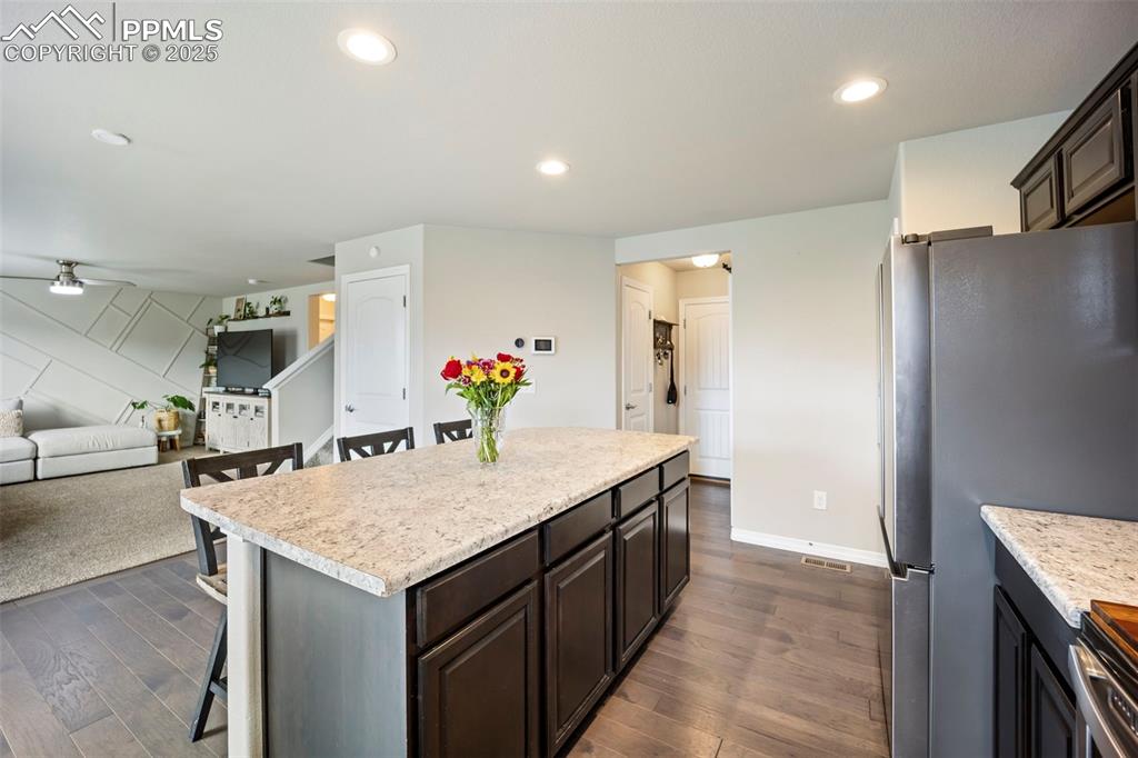 Image 9 of 45: Kitchen featuring a kitchen breakfast bar, freestanding refrigerator, reces
