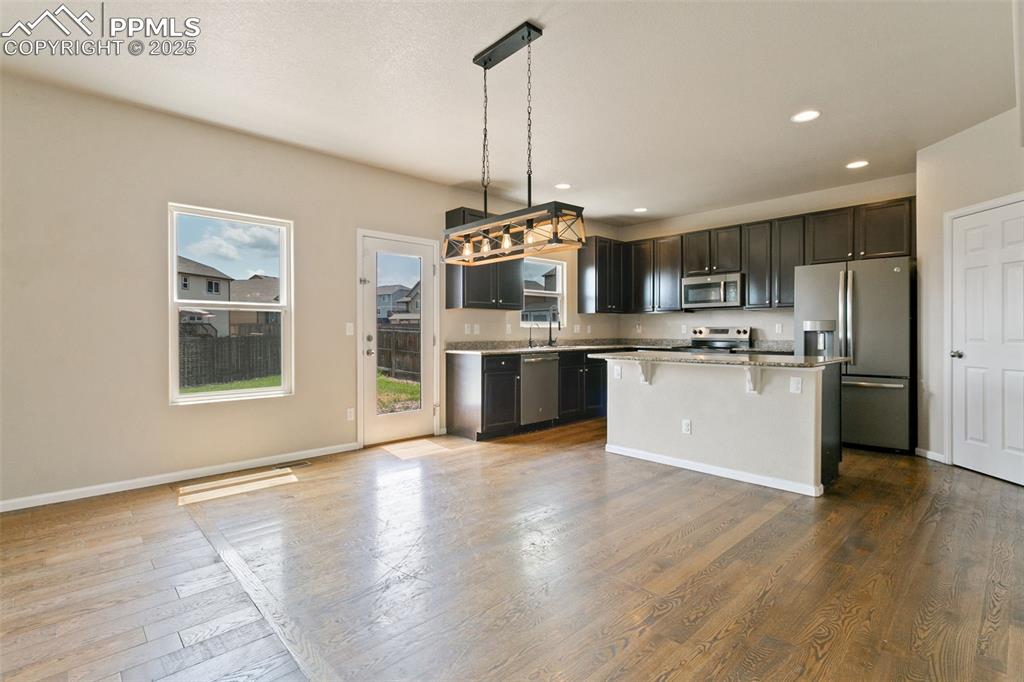 Image 15 of 41: Kitchen featuring stainless steel appliances, a breakfast bar area, a cente
