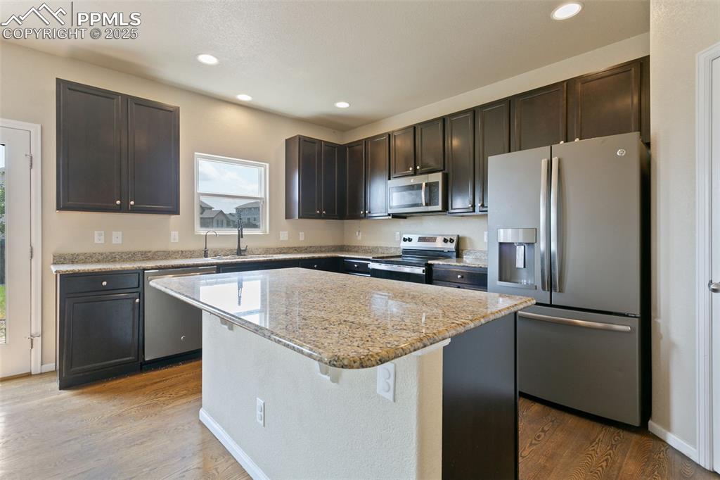 Image 16 of 41: Kitchen featuring stainless steel appliances, a center island, recessed lig