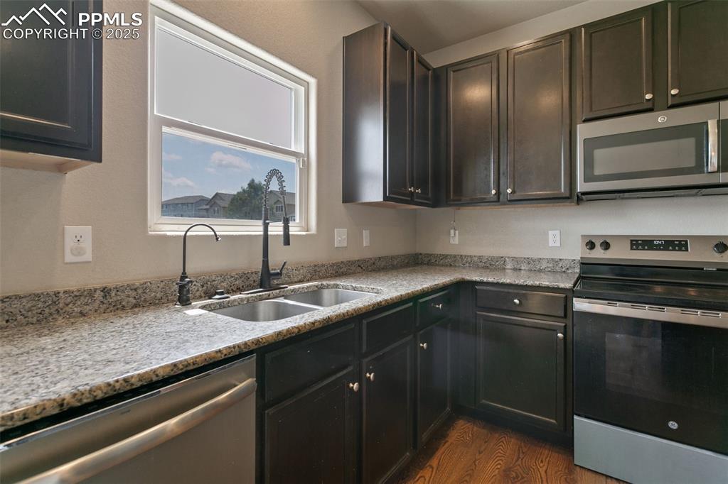 Image 18 of 41: Kitchen featuring stainless steel appliances and dark wood-style flooring
