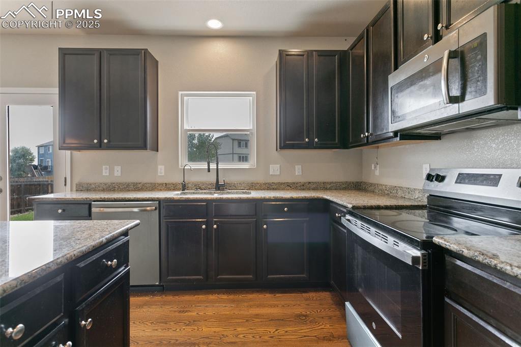 Image 21 of 41: Kitchen with stainless steel appliances, dark wood-type flooring, recessed 