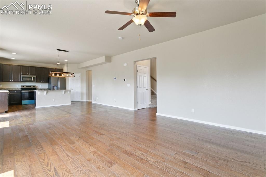 Image 23 of 41: Unfurnished living room featuring light wood-style floors and a ceiling fan