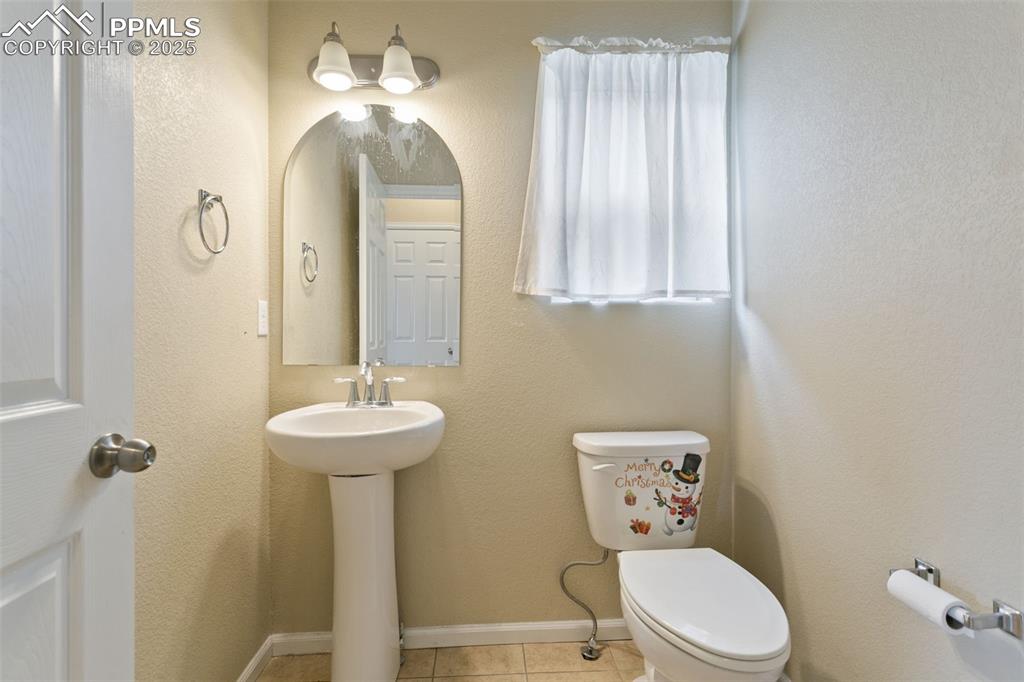 Image 24 of 41: Half bathroom with tile patterned flooring and a textured wall