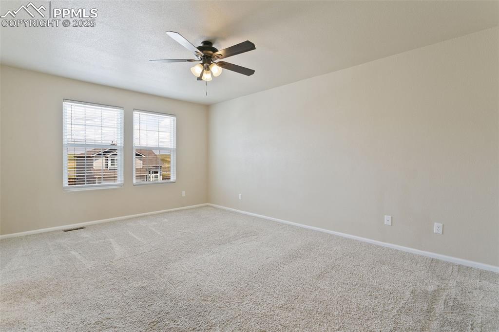Image 27 of 41: Empty room featuring carpet flooring, a ceiling fan, and a textured ceiling