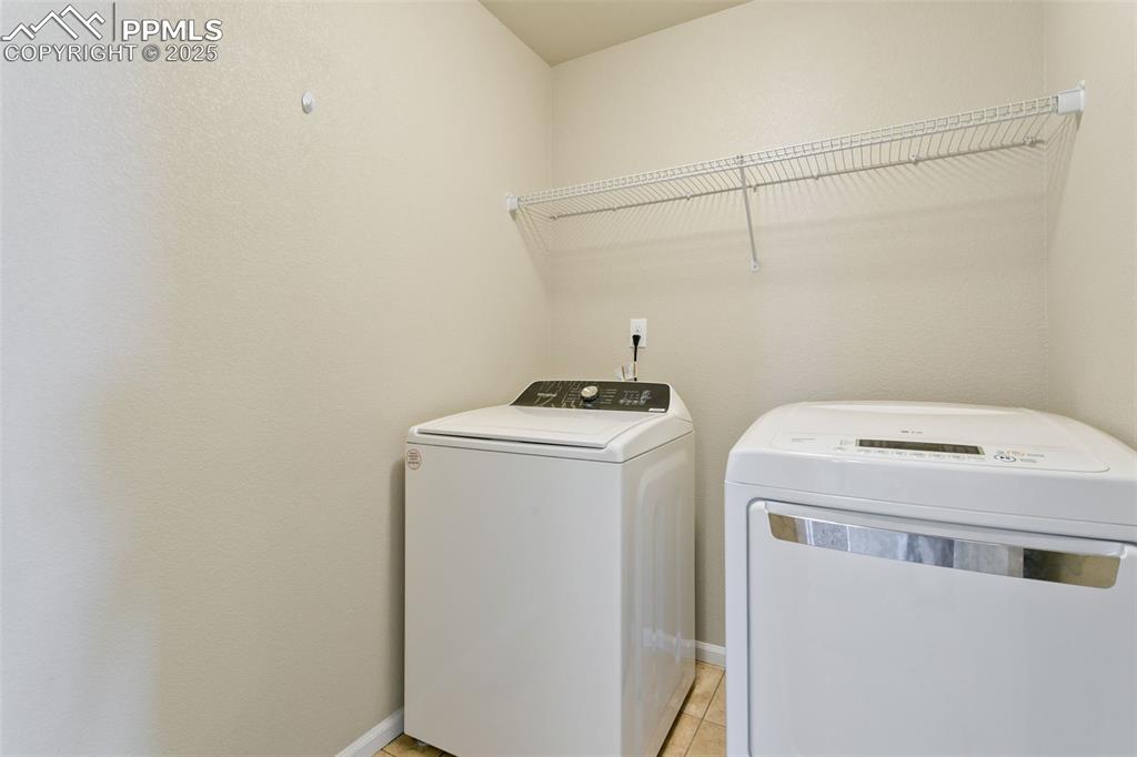 Image 37 of 41: Washroom featuring separate washer and dryer and light tile patterned floor