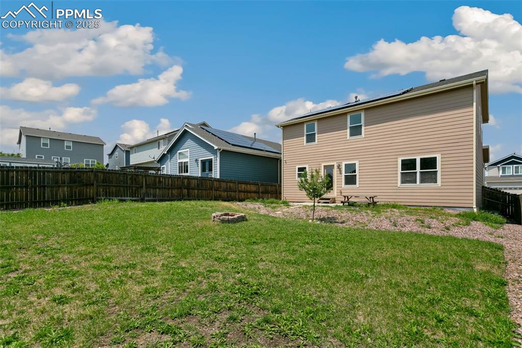 Image 41 of 41: Rear view of property featuring a fire pit, a fenced backyard, and a reside