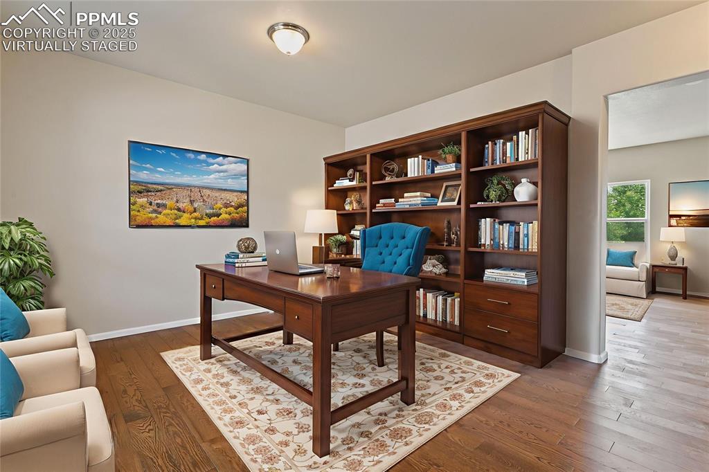 Image 5 of 41: Virtually Staged Home office with hardwood / wood-style flooring and basebo