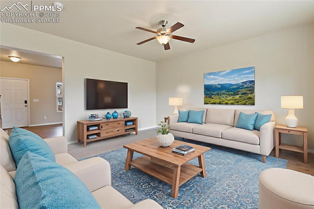 Image 7 of 41: Virtually Staged Living room with ceiling fan and wood finished floors