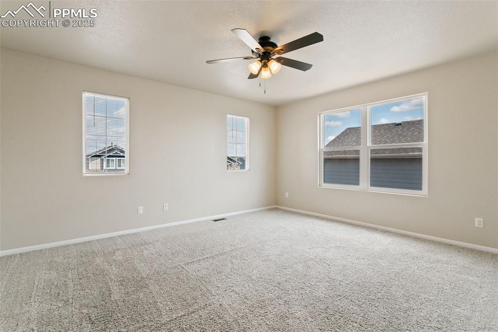 Image 8 of 41: Empty room with carpet floors, plenty of natural light, a ceiling fan, and 
