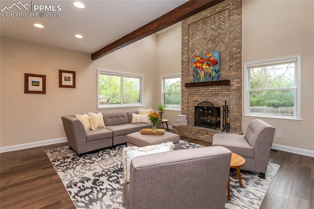 Image 14 of 50: Family room has a floor to ceiling fireplace, many windows and skylights to