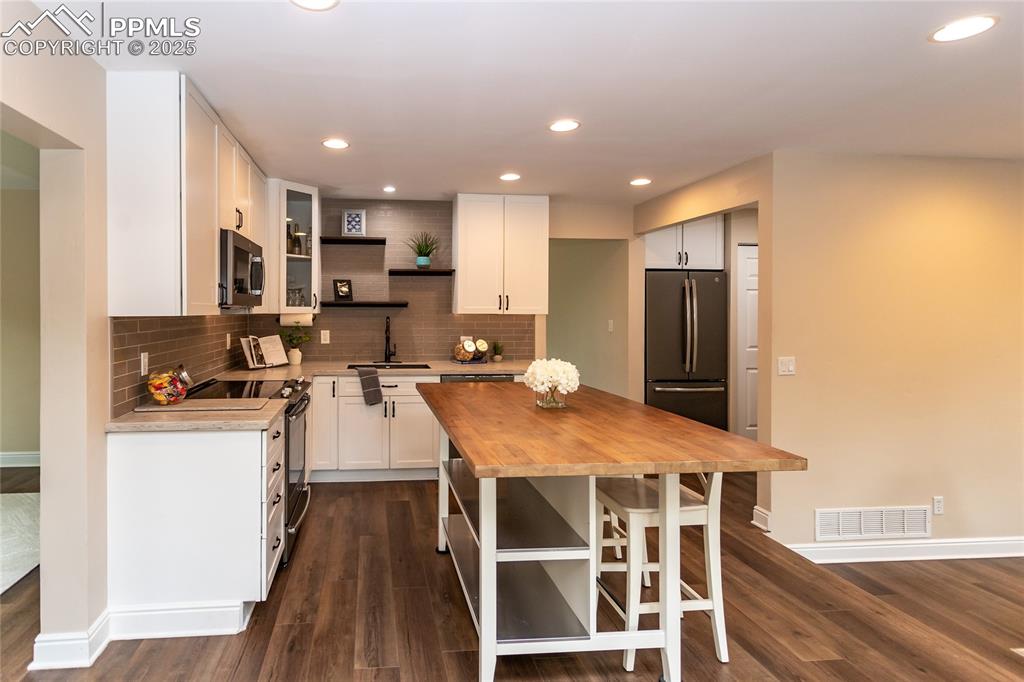 Image 18 of 50: Remodeled kitchen has newer cabinets, solid surface counters and stainless 