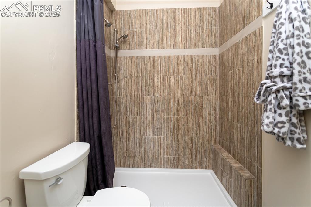Image 39 of 50: Tile floors and an oversized shower with tile surround in the Jack and Jill