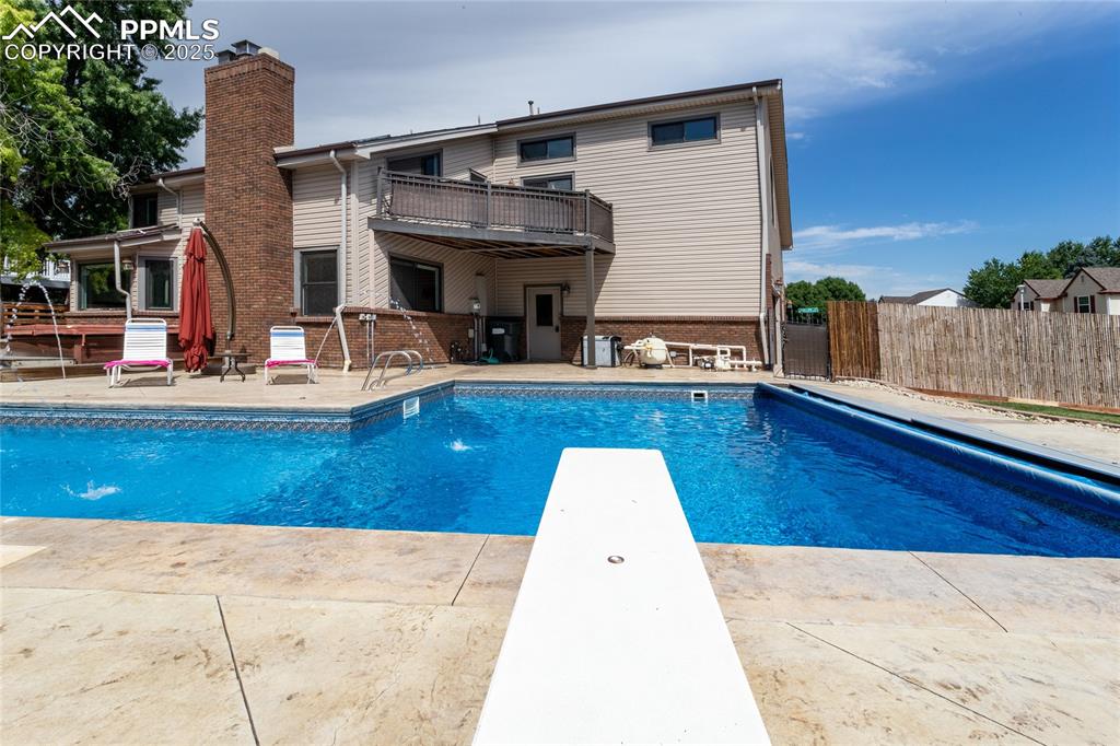 Image 48 of 50: View of swimming pool with a patio area and a diving board