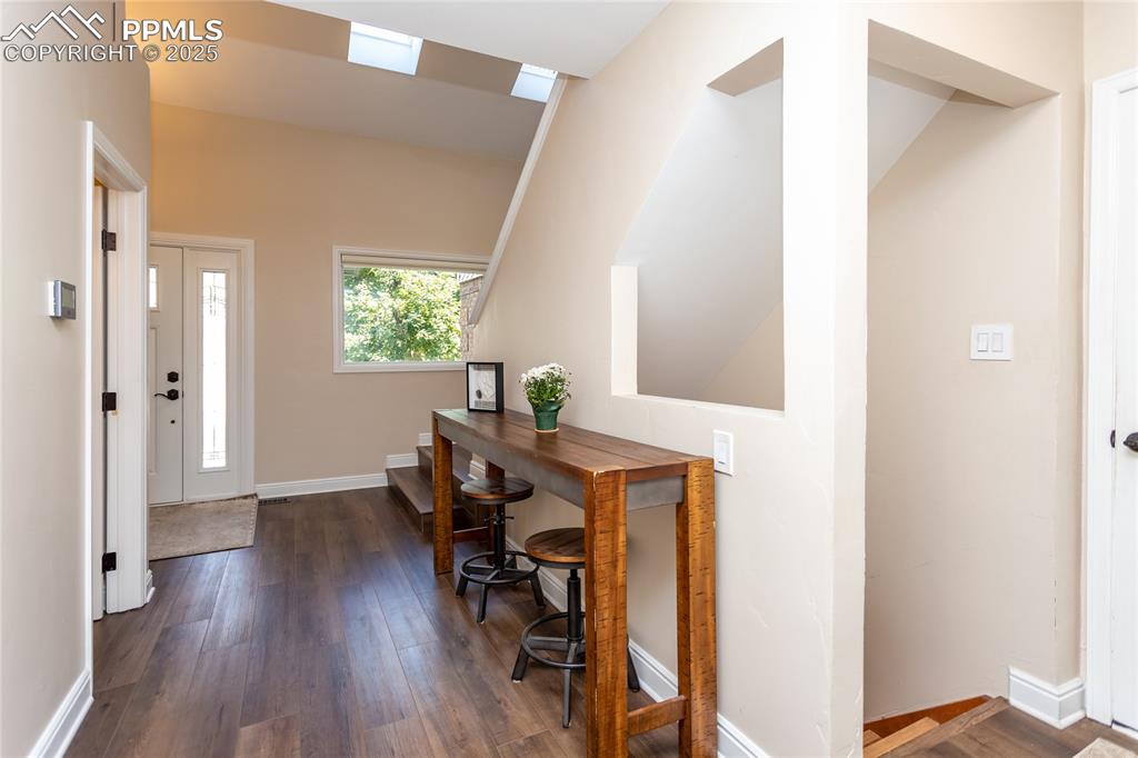Image 6 of 50: Specious entry area and staircase to the basement
