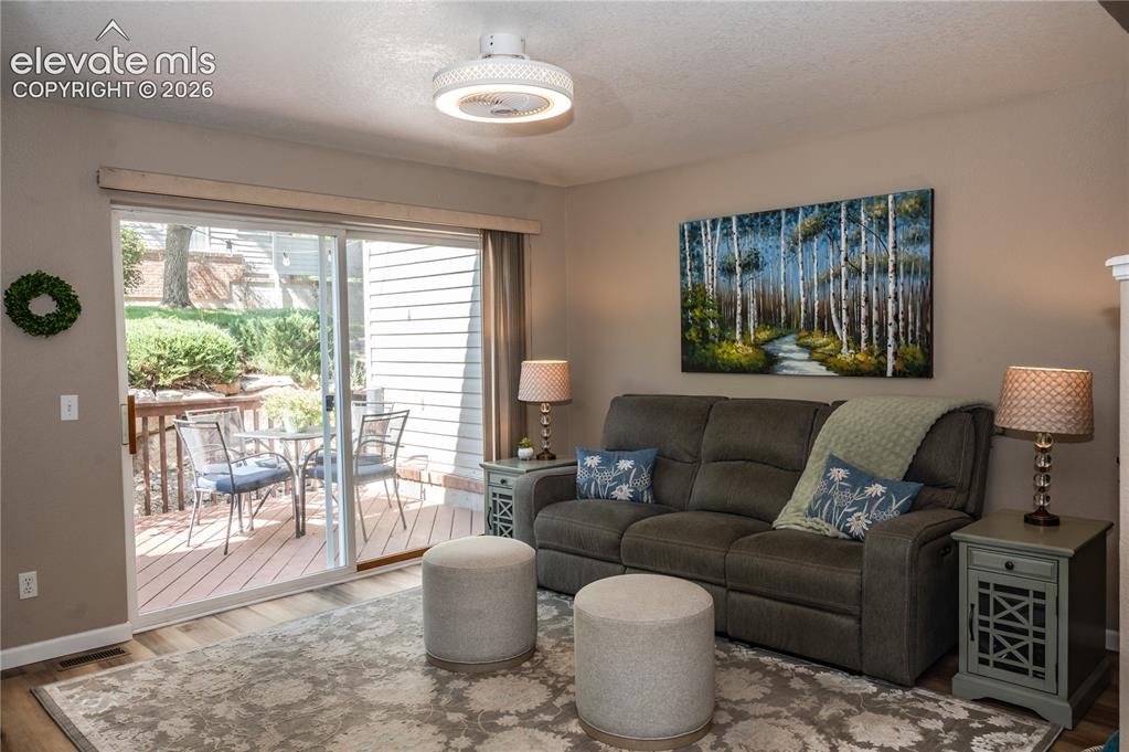 Image 6 of 34: Living room with sliding doors leading to deck