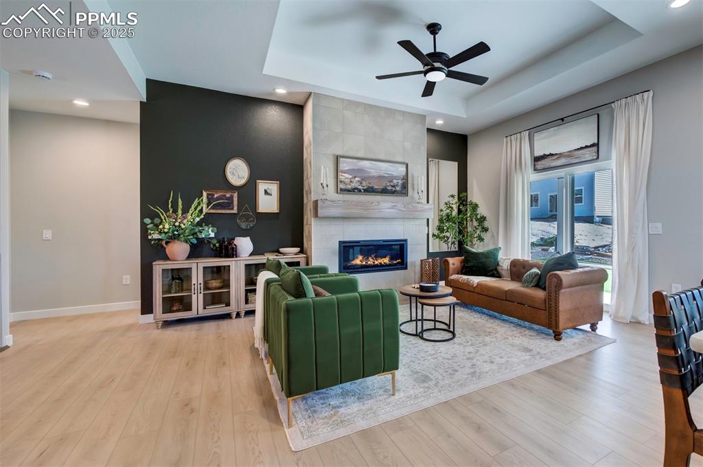 Image 17 of 44: Living area with recessed lighting, a raised ceiling, ceiling fan, and wood