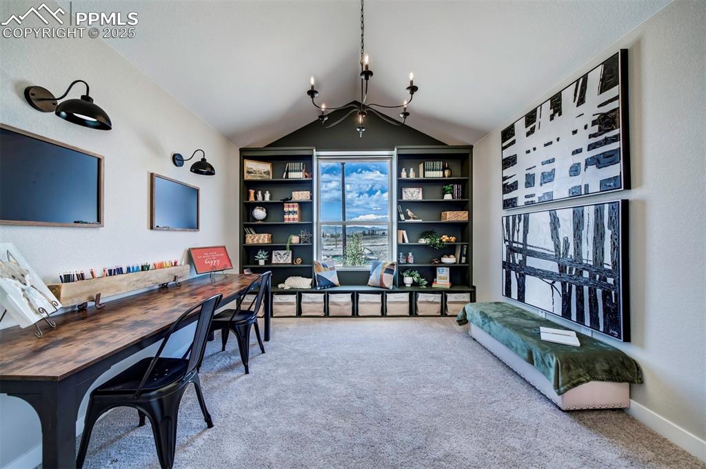Image 19 of 44: Home office featuring carpet floors, an inviting chandelier, and vaulted ce