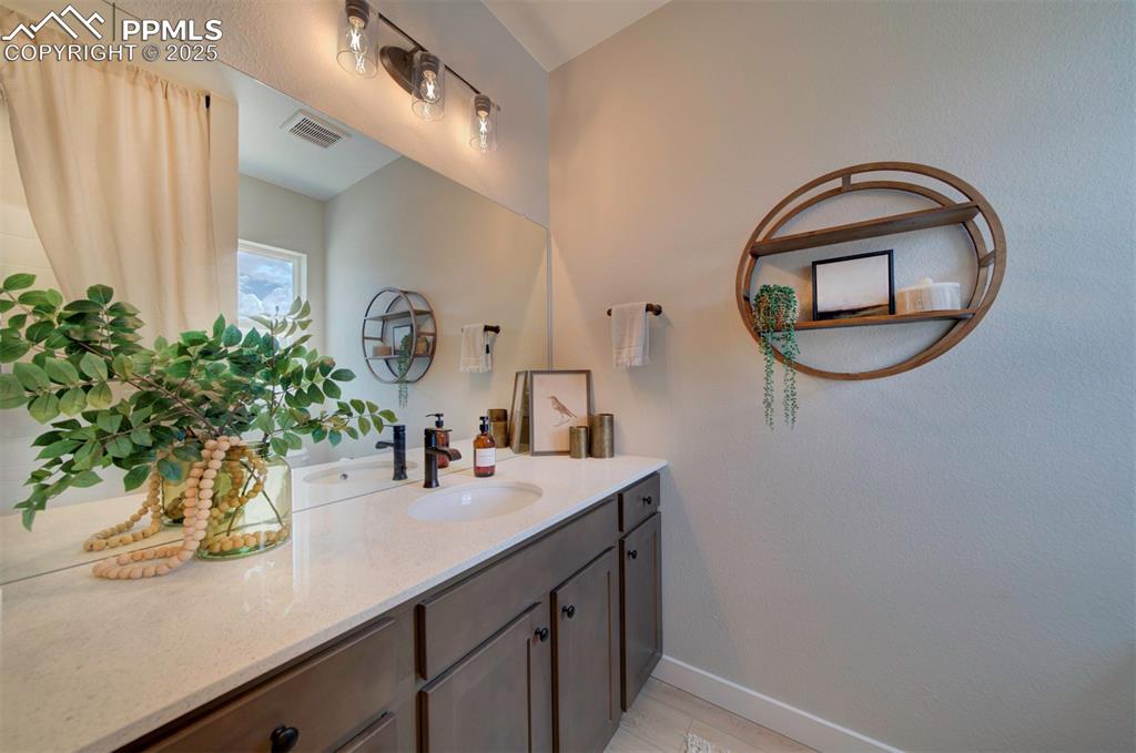 Image 22 of 44: Bathroom with vanity, baseboards, and visible vents