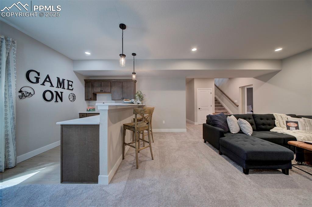 Image 24 of 44: Living area with recessed lighting, baseboards, light carpet, and stairway