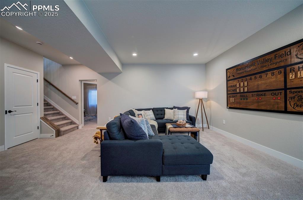 Image 26 of 44: Living area with stairs, recessed lighting, baseboards, and carpet