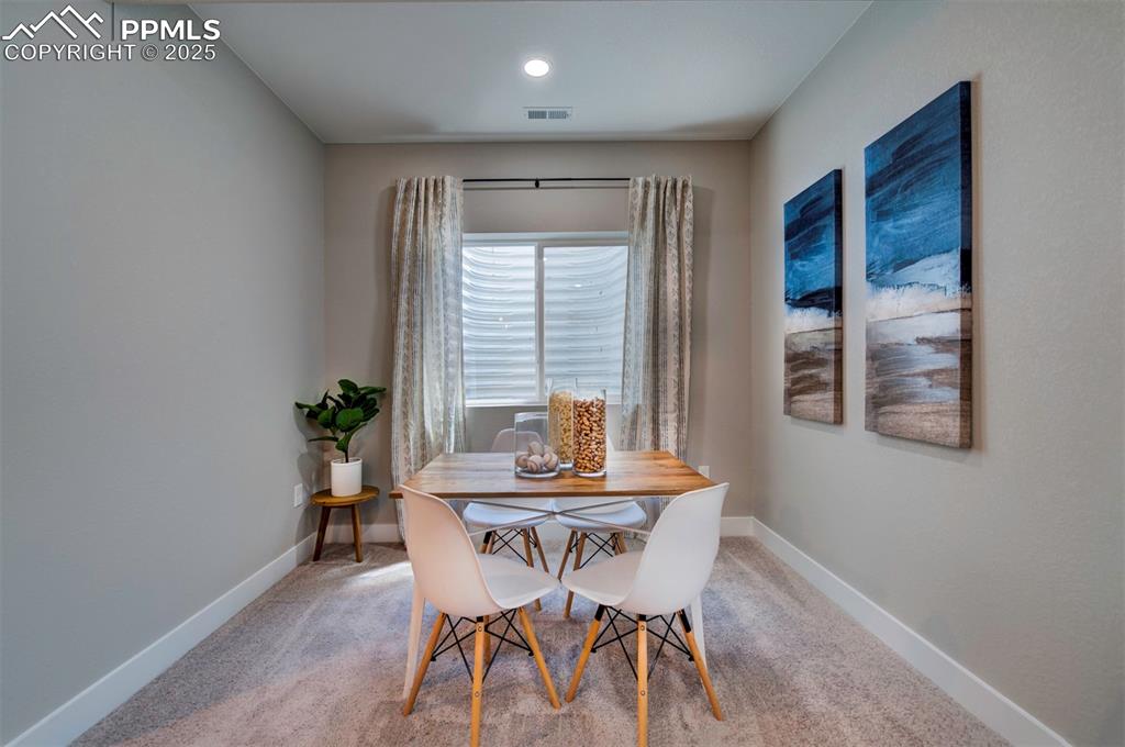Image 27 of 44: Carpeted dining space featuring baseboards and visible vents
