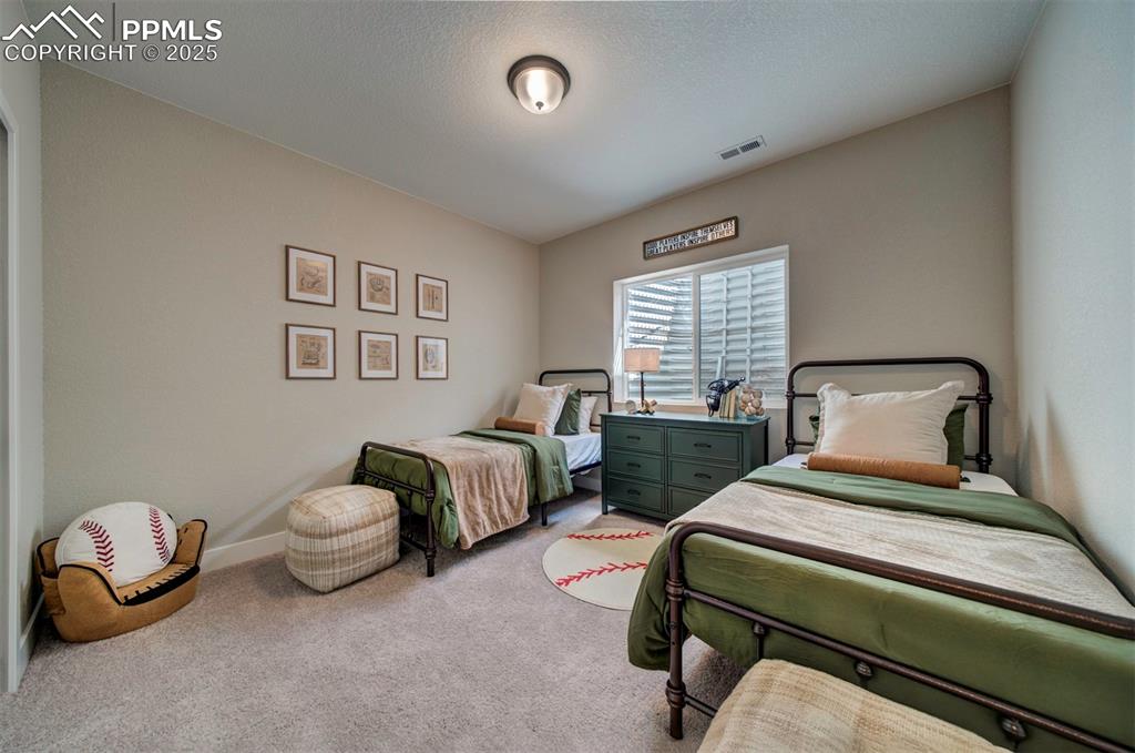Image 32 of 44: Carpeted bedroom with baseboards and visible vents