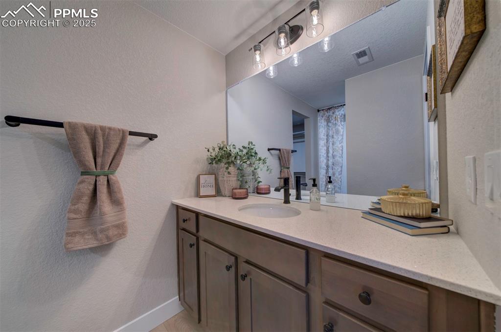 Image 39 of 44: Bathroom with visible vents, baseboards, and vanity