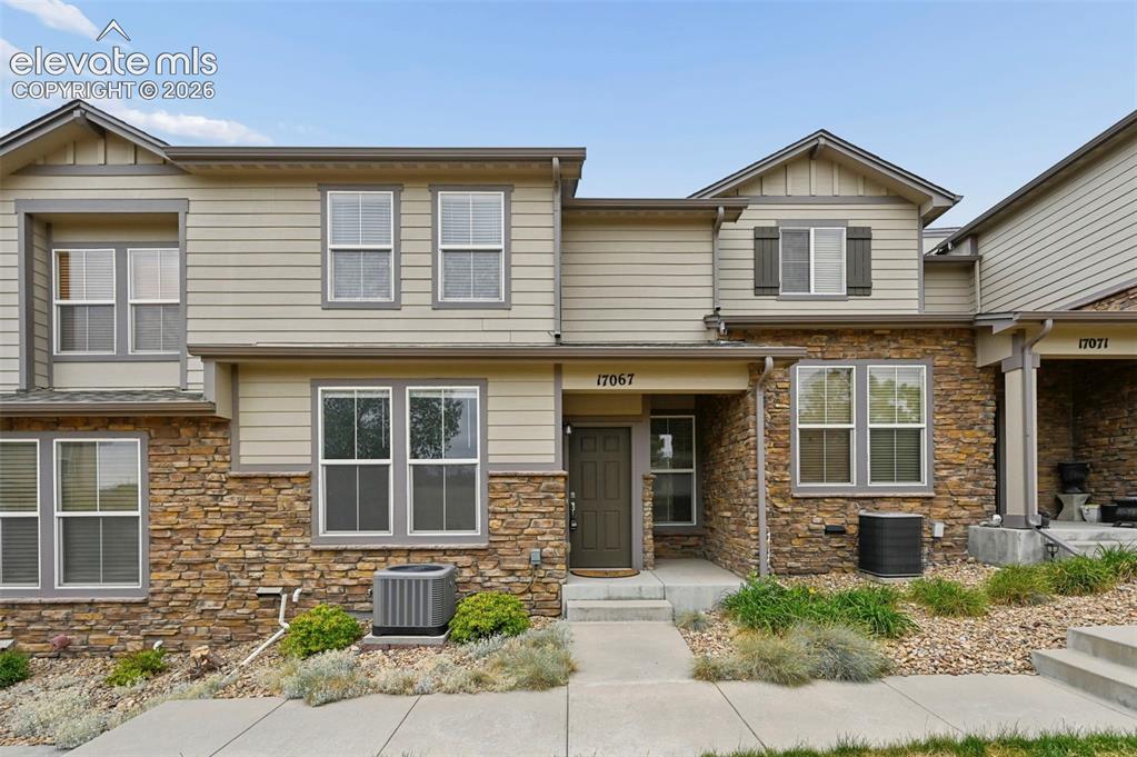 Image 1 of 33: Townhome exterior featuring stacked stone and horizontal siding