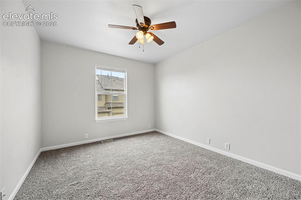 Image 10 of 30: Bright room featuring a ceiling fan with integrated lighting, neutral wall 