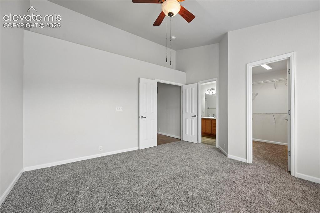 Image 13 of 33: Spacious room featuring vaulted ceilings, ceiling fan with light fixture, l