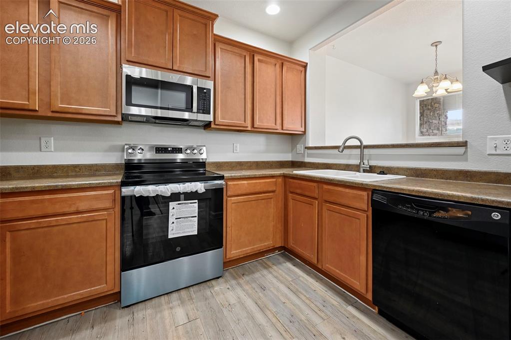 Image 3 of 30: Kitchen featuring wood cabinetry, laminate countertops, stainless steel mic