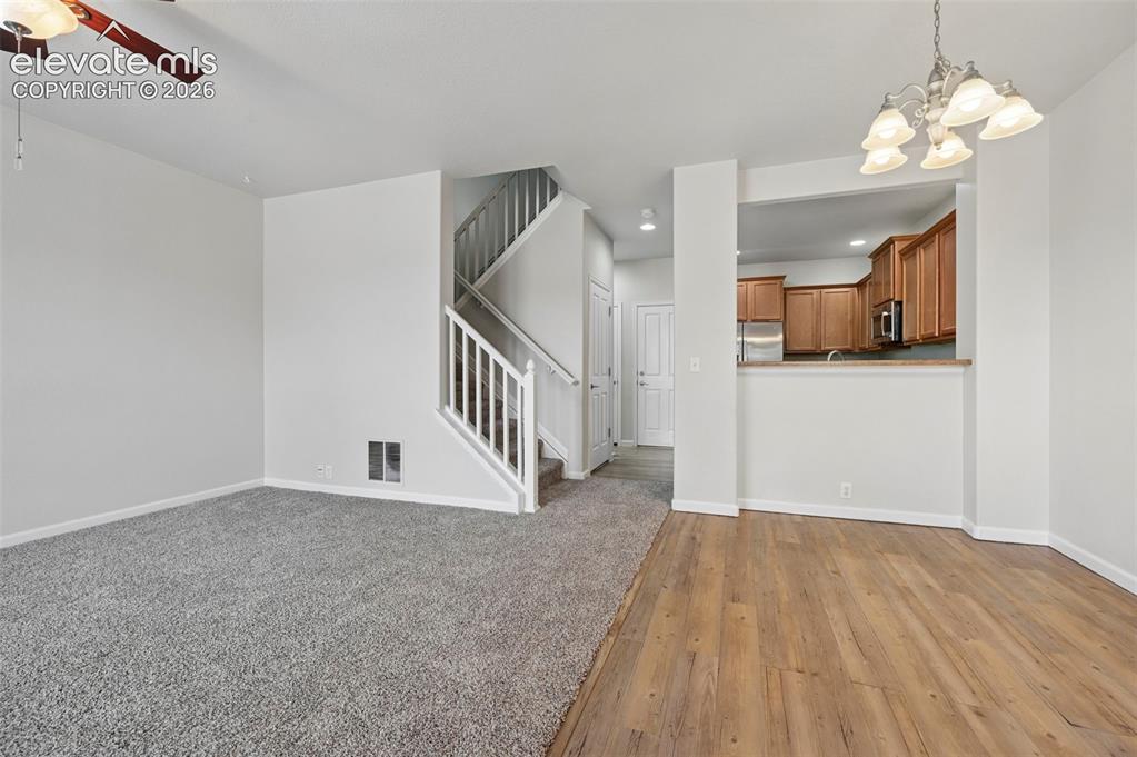 Image 33 of 33: Open-concept living space featuring wood-finish flooring, a contemporary ch