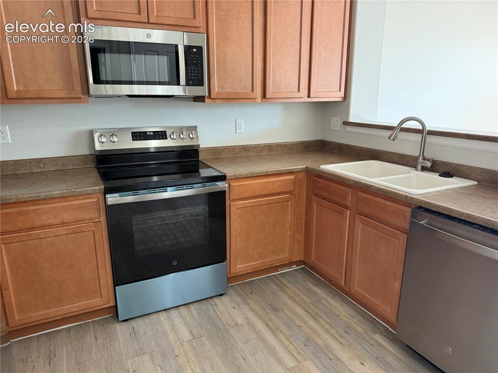 Image 4 of 33: Kitchen featuring wood-finish cabinetry, laminate countertops, a stainless